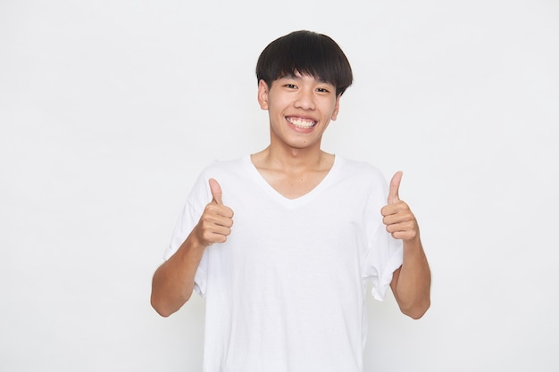 Aziatische jonge man met een T-shirt duim omhoog op een witte ondergrond.