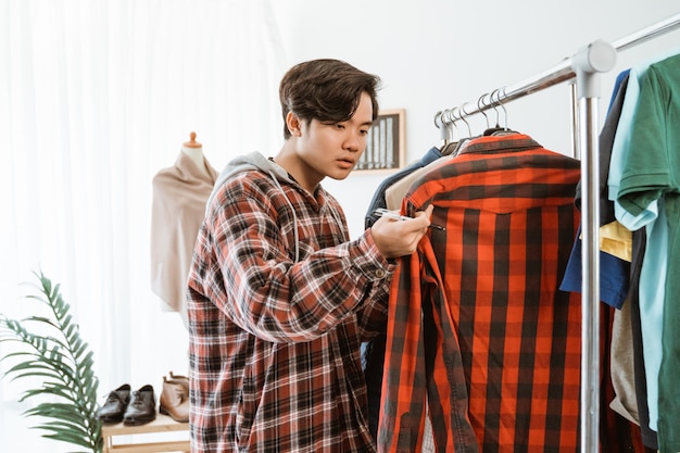 Aziatische jonge man winkelen in een kledingwinkel