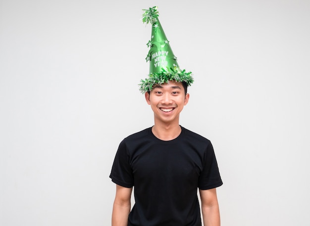 Aziatische jonge man zwart shirt met groene hoed, gelukkige glimlach en vrolijk gelukkig nieuwjaarsconcept