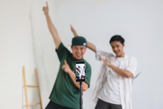 Foto aziatische jonge tiener met haar vriend tiktoker creëerde samen een dansvideo met een smartphonecamera