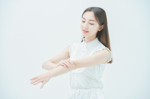 Aziatische jonge vrouw die de conditie van de huid op haar armen controleert