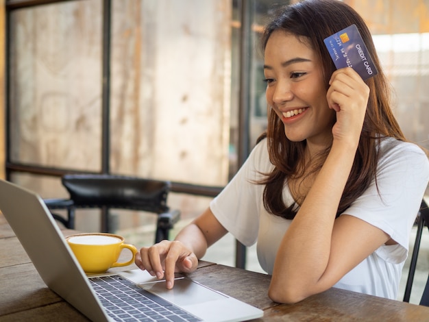 Aziatische jonge vrouw die een creditcard houdt