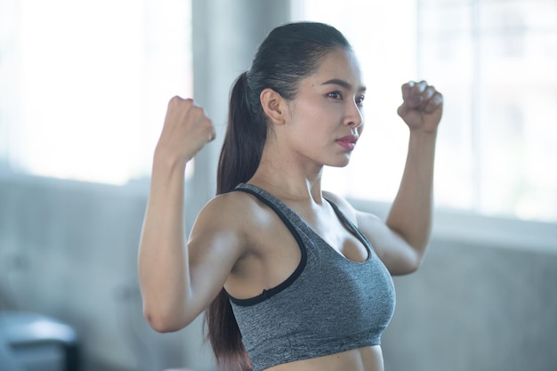 Foto aziatische jonge vrouw die traint in de sportschool verbeter de gezondheid voor kracht oefeningsconcept