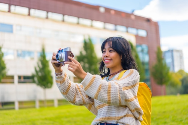 Aziatische jonge vrouw fotografie met een vintage fotocamera een bezoek aan een city park backpacker reiziger concept