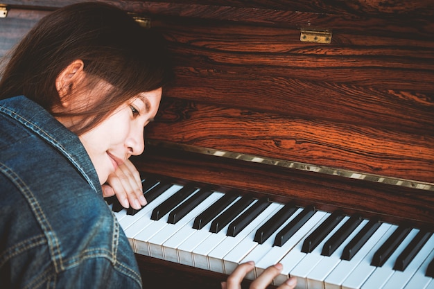 Aziatische jonge vrouw het spelen piano