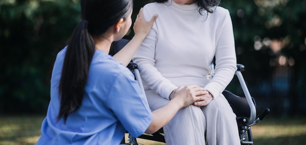 Aziatische jonge vrouw verpleegster in verpleeghuis zorg gehandicapte senior man Verzorger arts dient fysiotherapie voor oudere oudere patiënt om te oefenen en te oefenen met lopen op rollator of stok in de achtertuin