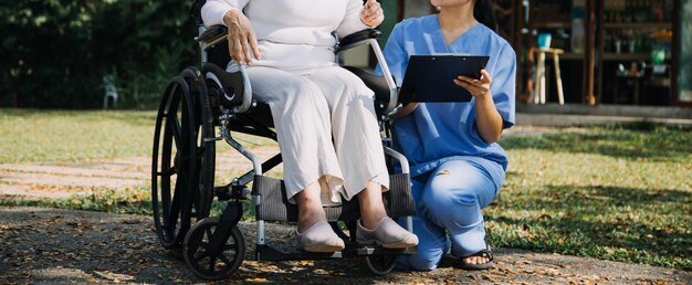 Aziatische jonge vrouw verpleegster in verpleeghuis zorg gehandicapte senior man Verzorger arts dient fysiotherapie voor oudere oudere patiënt om te oefenen en te oefenen met lopen op rollator of stok in de achtertuin