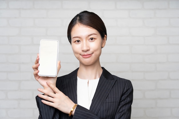 Aziatische jonge zakenvrouw werkende smartphone