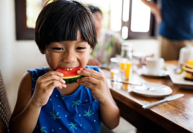 Aziatische jongen die op een watermeloen snacking