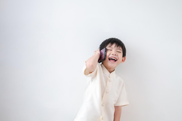Aziatische jongen Draag traditionele Thaise kleding Praat aan de telefoon op een witte achtergrond