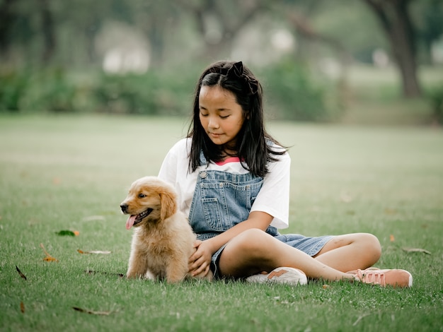 Aziatische jongen en meisjes het spelen wiyh puppyhond in park