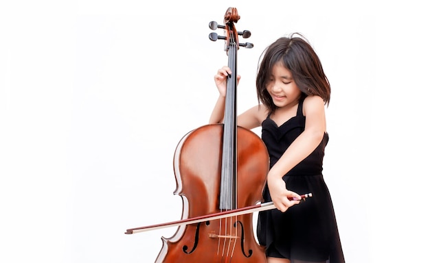 Aziatische jongen houdt van klassieke muziek met cello snaarinstrument op witte geïsoleerde achtergrond. muziek onderwijs klasse concept