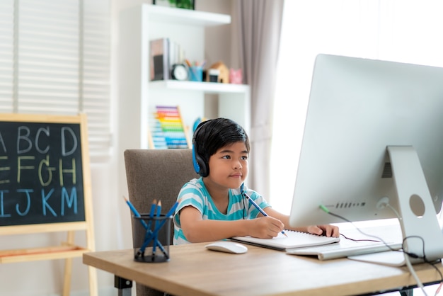 Aziatische jongen student videoconferentie e-learning met leraar en klasgenoten op de computer