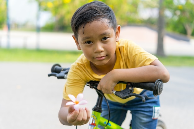 Aziatische jongens berijdende fiets in openbaar park