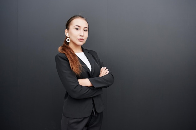 Aziatische Kazachse zakenvrouw makelaar in pak op zwarte muur achtergrond