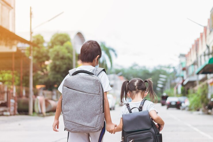 Aziatische kinderen dragen een gezichtsmasker en nemen een schooltas mee Terug naar school