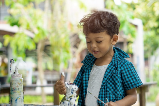 Aziatische kinderen genieten van zijn schilderij met handen