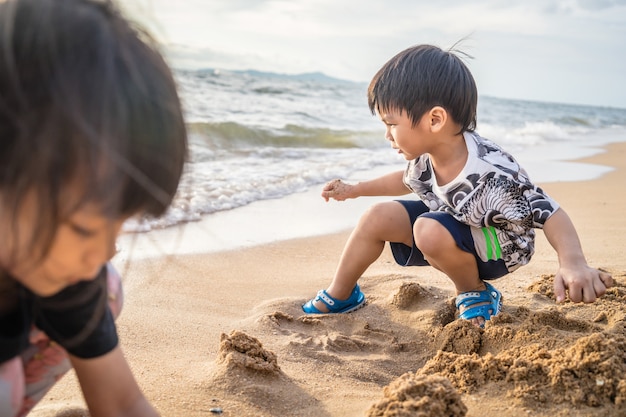 Aziatische kinderen spelen zand op het strand