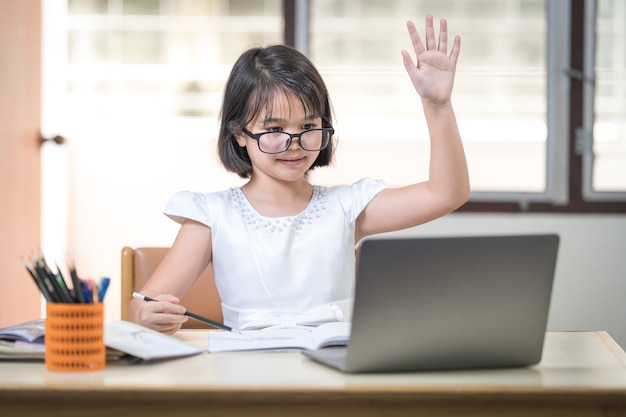 Aziatische kinderen studente met bril online studeren, huiswerk op laptop thuis. Onderwijsconcept Stock Photo