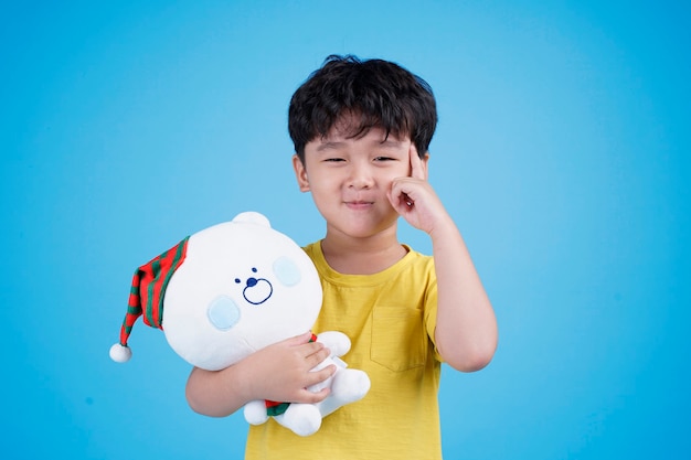 Aziatische kleine jongen jongen houden en knuffelen teddybeer pop