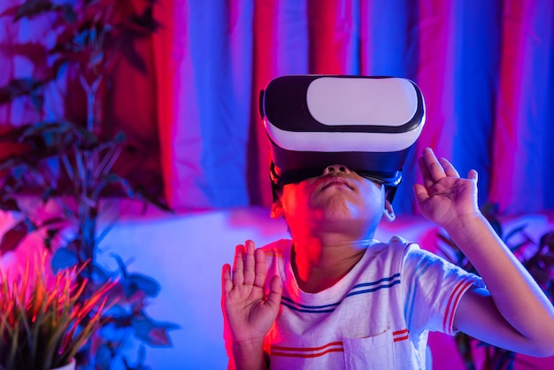 Aziatische kleine jongen met een virtual reality-bril die de realiteit ervaart