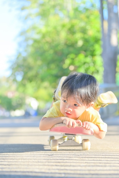 Aziatische kleine jongen op skate board. de jongen leert schaatsen