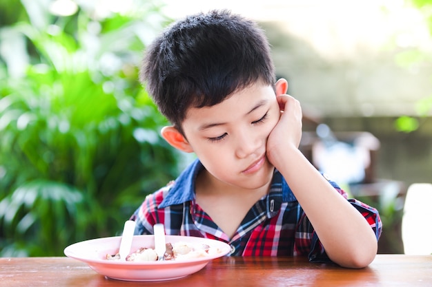 Aziatische kleine jongen saai eten rijst