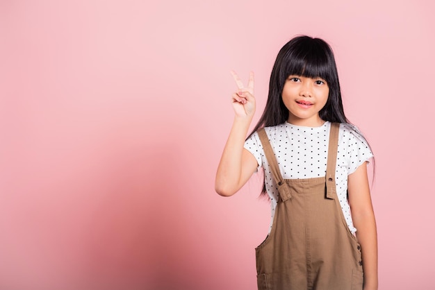 Aziatische kleine jongen van 10 jaar toont vsign vingers gebaar