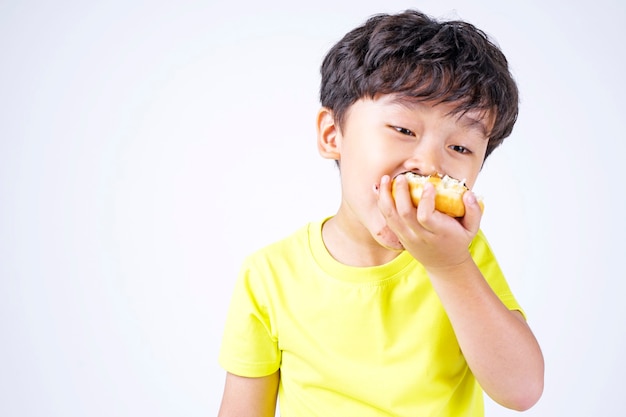 Aziatische kleine schattige jongen grote donut eten