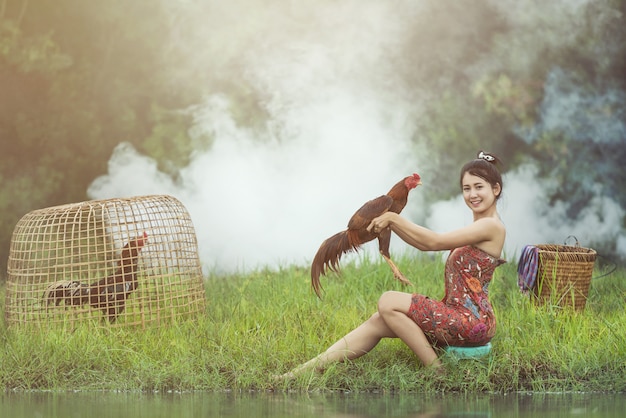 Aziatische lokale vrouw met hanengevechten, thailand