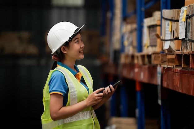 Foto aziatische magazijnmedewerker controleer de voorraad met een tablet- en barcode-opener-bedrijfsidee