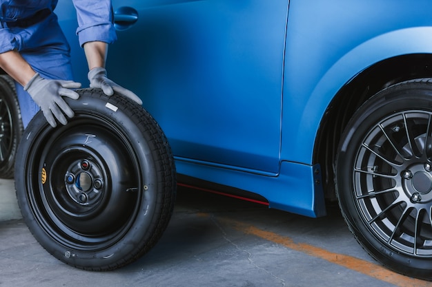 Aziatische man auto-inspectie Meet de hoeveelheid opgeblazen rubber banden auto