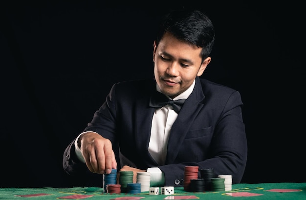 Aziatische man dealer of croupier schudt pokerkaarten weddenschappen in casino op zwarte achtergrond van groene tafel Dealer man uitnodiging inzet speelkaarten Casino poker pokerspel concept