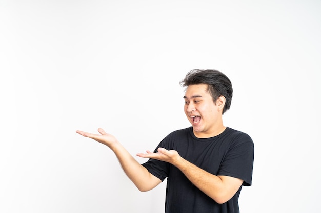 Aziatische man die lacht met beide handen die iets presenteert