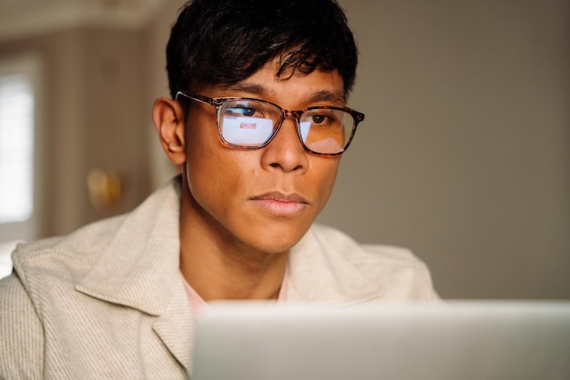 Aziatische man die online werkt met een bril