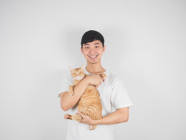 Aziatische man draagt een oranje kat met een vrolijke glimlach, vrolijk en kijkt naar de camera op een witte geïsoleerde achtergrond