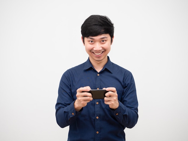 Aziatische man gamer die mobiele telefoon vasthoudt met een gelukkig glimlachgezicht dat naar de camera kijkt