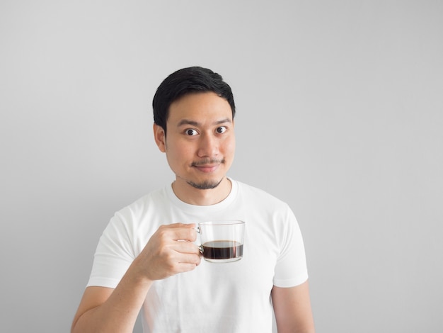 Aziatische man in wit t-shirt drinkt een kopje koffie.