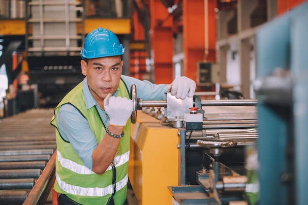 Aziatische man ingenieur werkt hard in fabrieksarbeider werknemer veiligheidshelm veiligheidscontrole machine fabriek