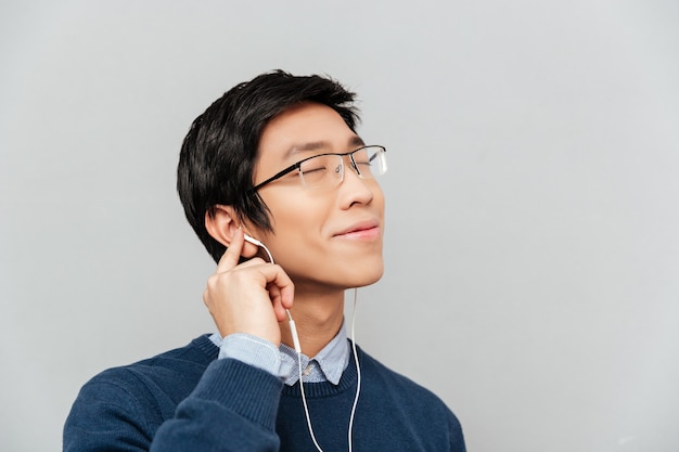 Aziatische man luisteren naar muziek op koptelefoon.