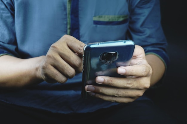 Aziatische man met donkerbruine huid met smartphone