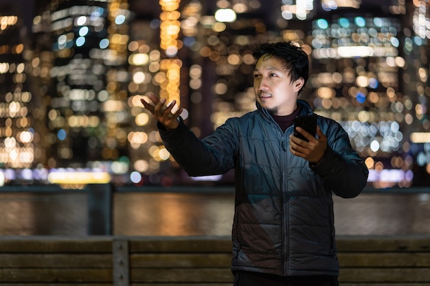 Aziatische man met overjaspak met slimme mobiele telefoon met glimlachactie