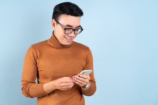 Aziatische man met smartphone op blauwe achtergrond