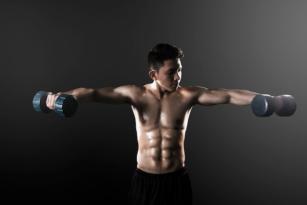 Aziatische man traint zijn biceps met halters