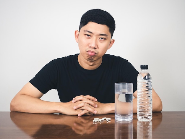 Aziatische man verveelt zich met medicijnpil op tafel