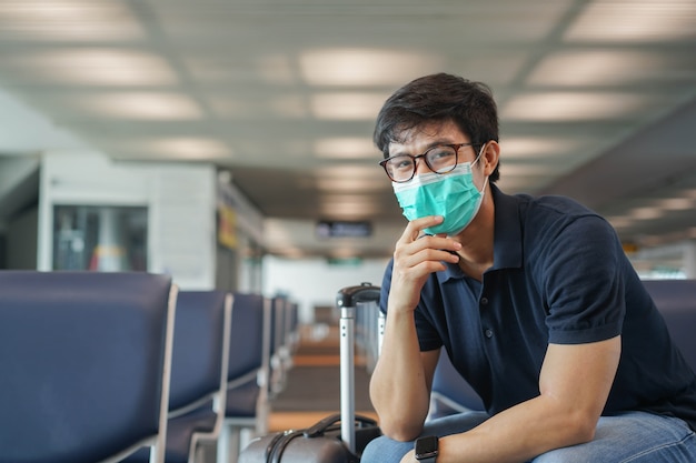 Aziatische man zit alleen in de lounge te wachten boarding tijd vorm luchtvaartmaatschappij