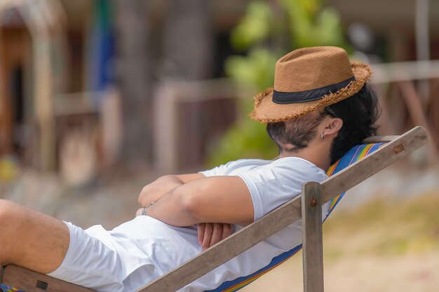 Aziatische man zit stoel strand in zee Ontspan tijd in de zomer