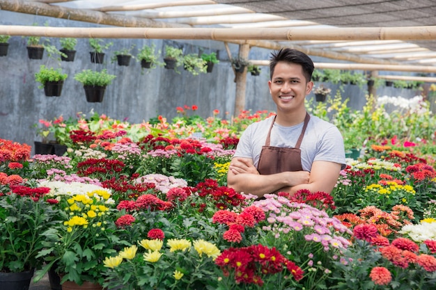 Aziatische mannelijke bloemist die in bloemenwinkel werkt