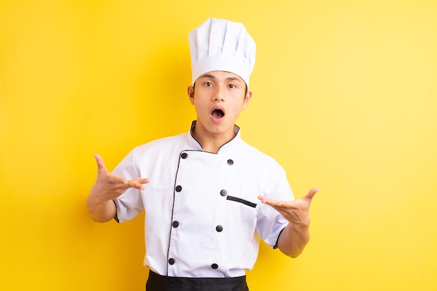 Aziatische mannelijke chef-kok op geel