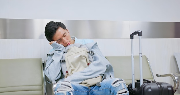 Aziatische mannelijke luchthaven slaperig wachten